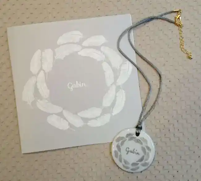 Pendentif rond en porcelaine personnalisé d'après le faire-part de naissance.