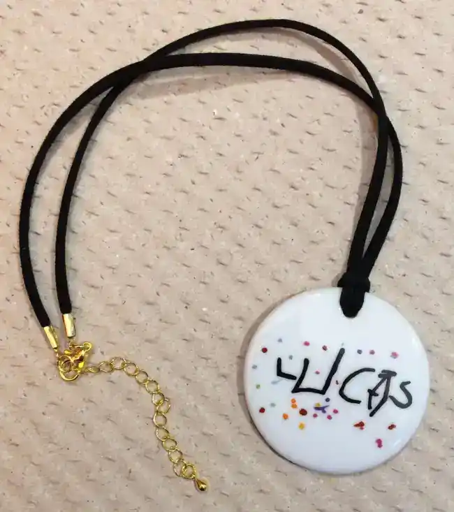 Pendentif rond en porcelaine personnalisé d'après un dessin d'enfant.