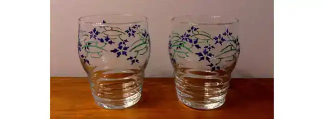 Deux verres à vin cuit personnalisés par une frise de bleuets.