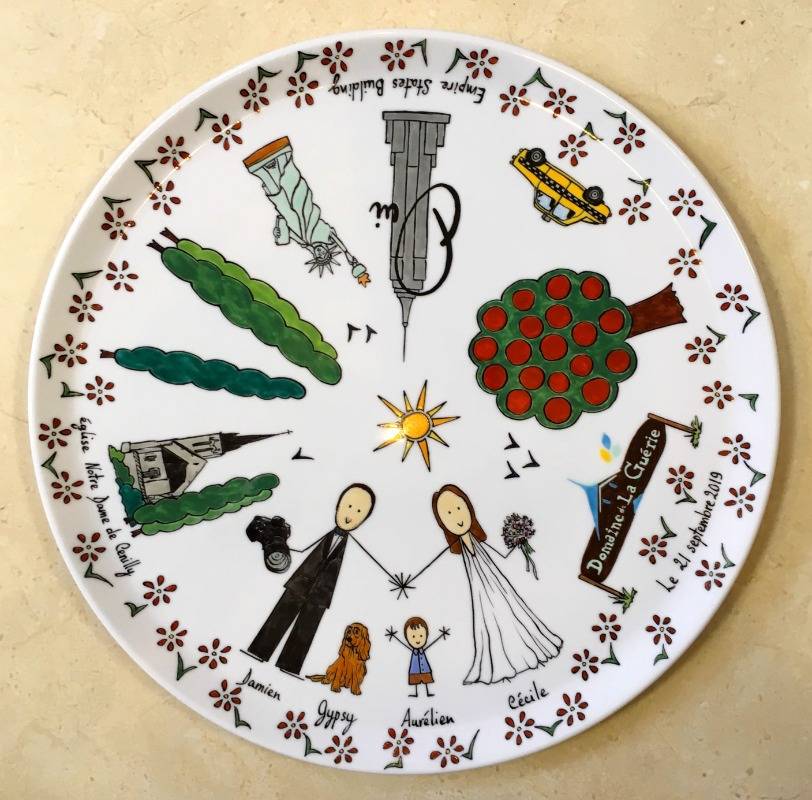 Plat à tarte en porcelaine personnalisé à l'occasion d'un mariage dans un style naïf avec différentes étapes de la vie du couple.