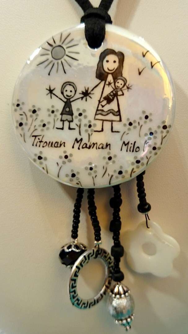 Pendentif rond en porcelaine avec breloques personnalisé dans un style naïf avec le bébé dans les bras de sa maman
