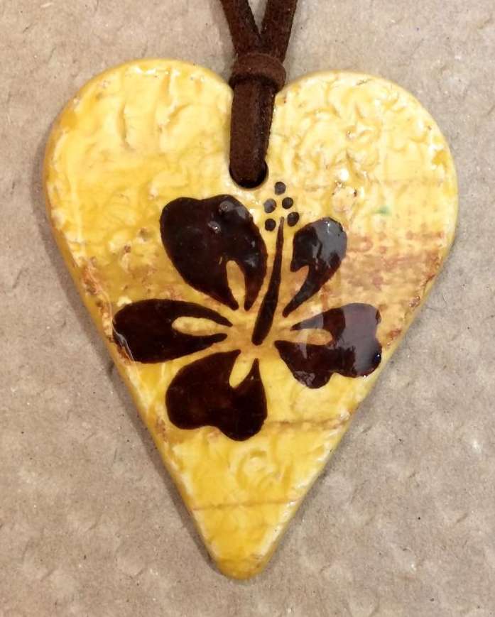 Pendentif coeur en céramique jaune personnalisé par une fleur chocolat.