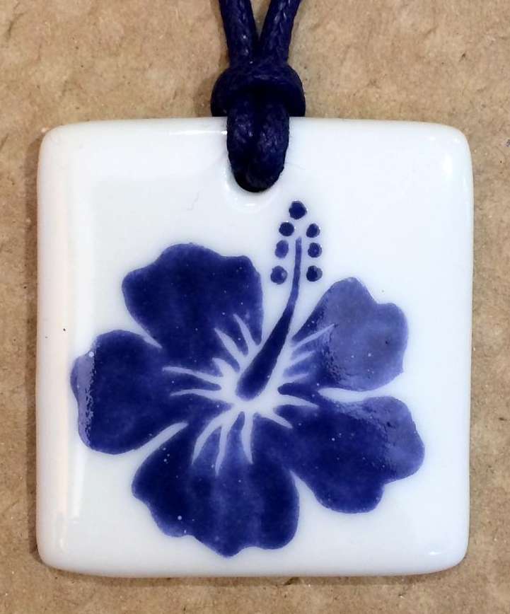 Pendentif carré en porcelaine personnalisé une fleur bleue.
