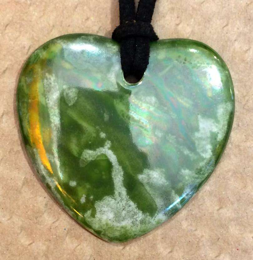 Pendentif coeur en porcelaine personnalisé par un fond vert.